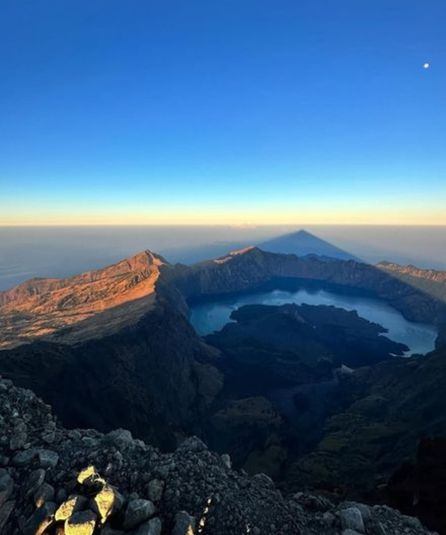 Volcano crater lake sunrise shadow
