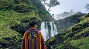 Man in colorful poncho, waterfall